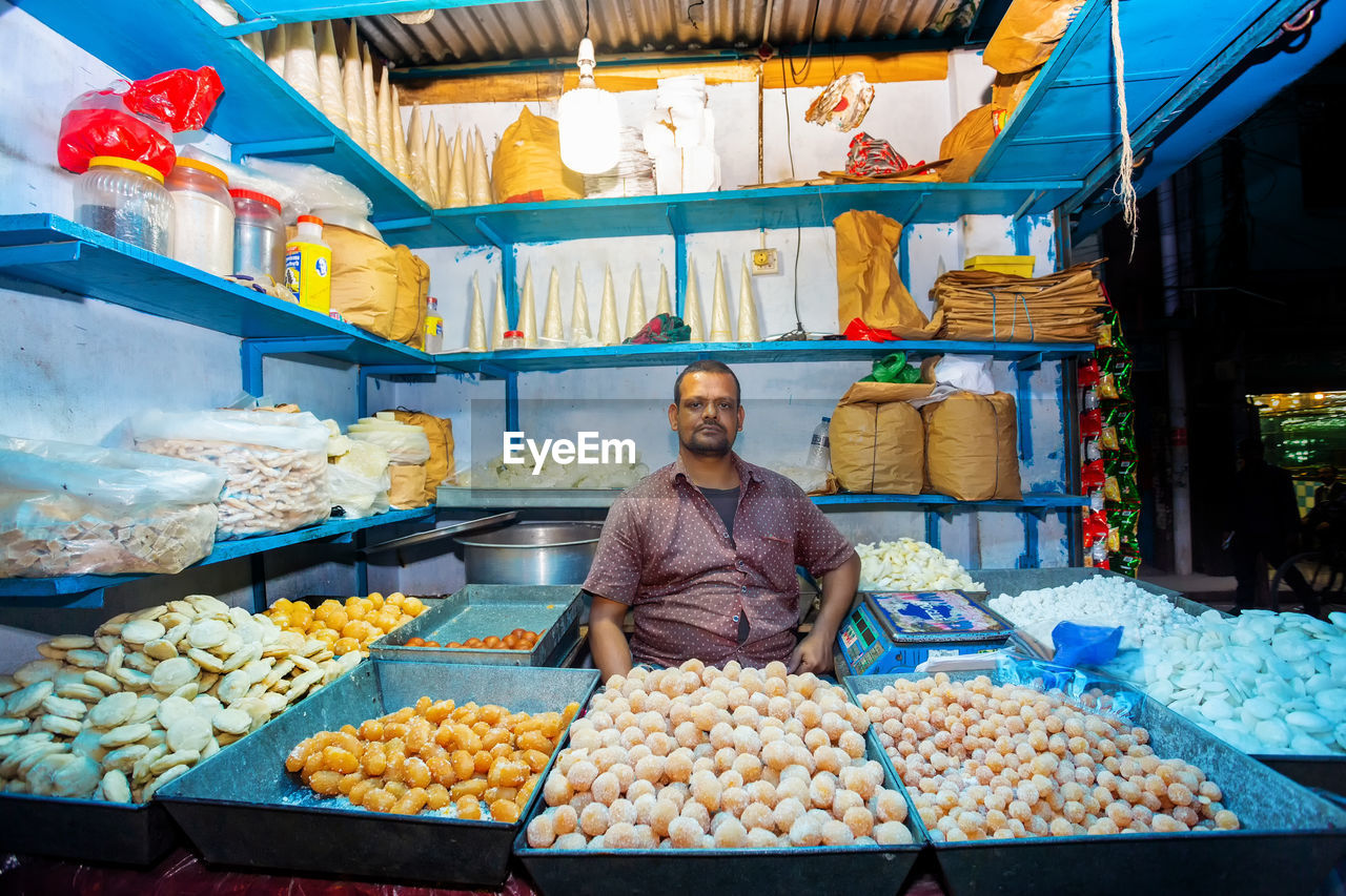 FULL LENGTH PORTRAIT OF A MAN STANDING IN MARKET