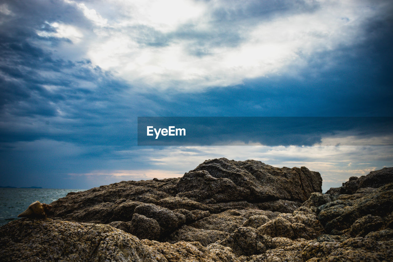 Rock formation on beach against sky