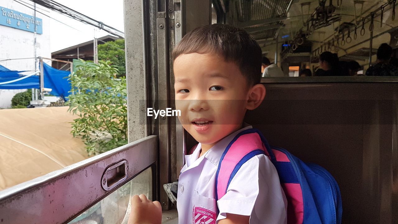 PORTRAIT OF CUTE BOY LOOKING AWAY WHILE MAN