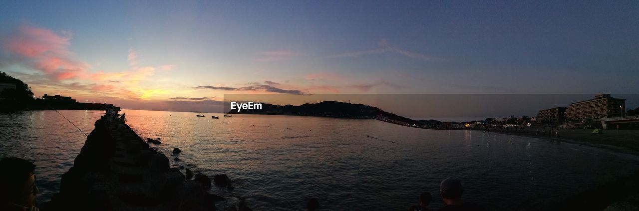 PANORAMIC VIEW OF CALM SEA AGAINST SKY AT SUNSET