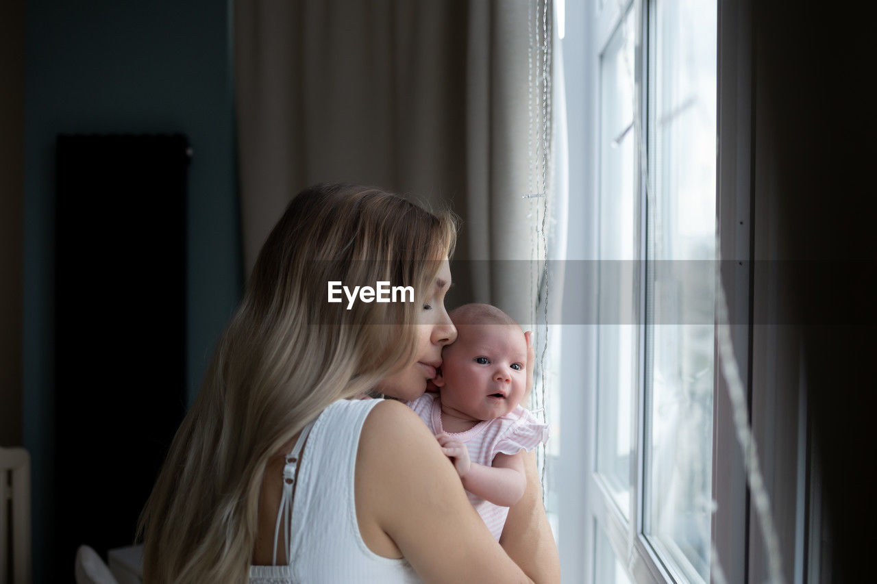 side view of boy looking through window