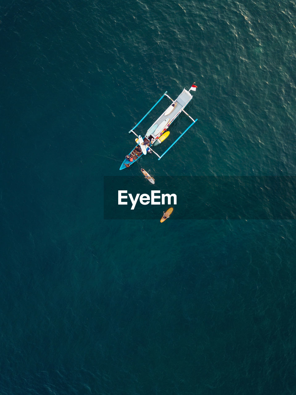 Aerial view of surfers and boat in the ocean, lombok, indonesia