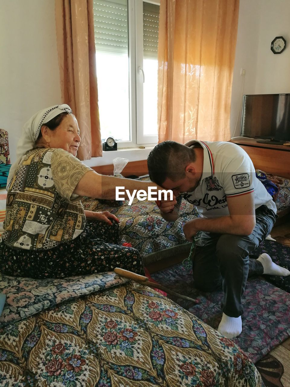 WOMAN SITTING ON SOFA AT HOME