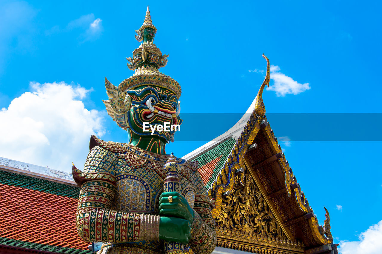 Low angle view of demon statue at grand palace against sky