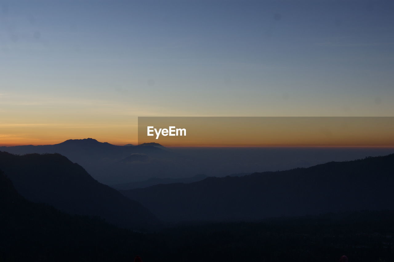 Scenic view of silhouette mountains against sky during sunset