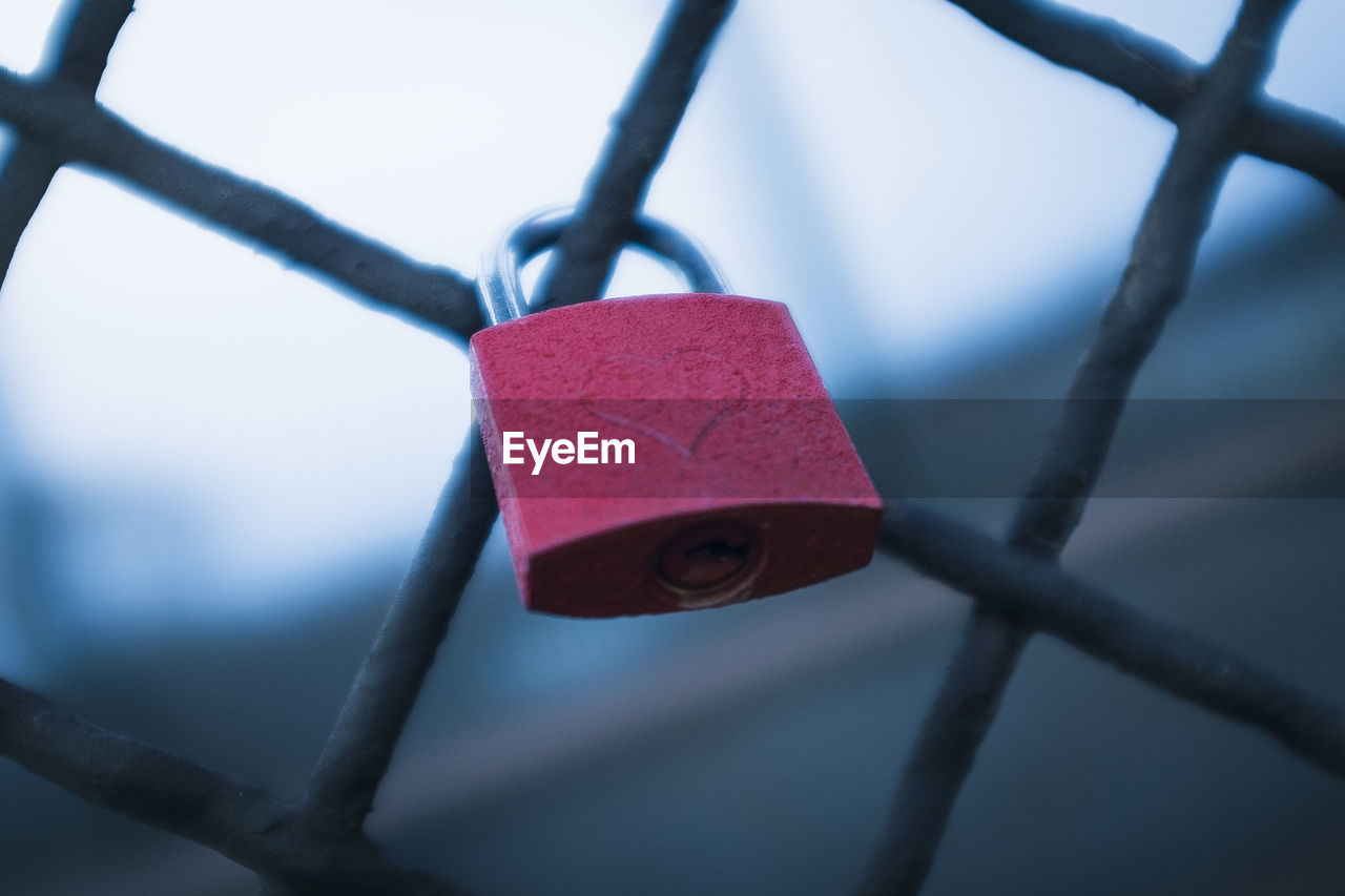 Close-up of padlock attached to chainlink fence