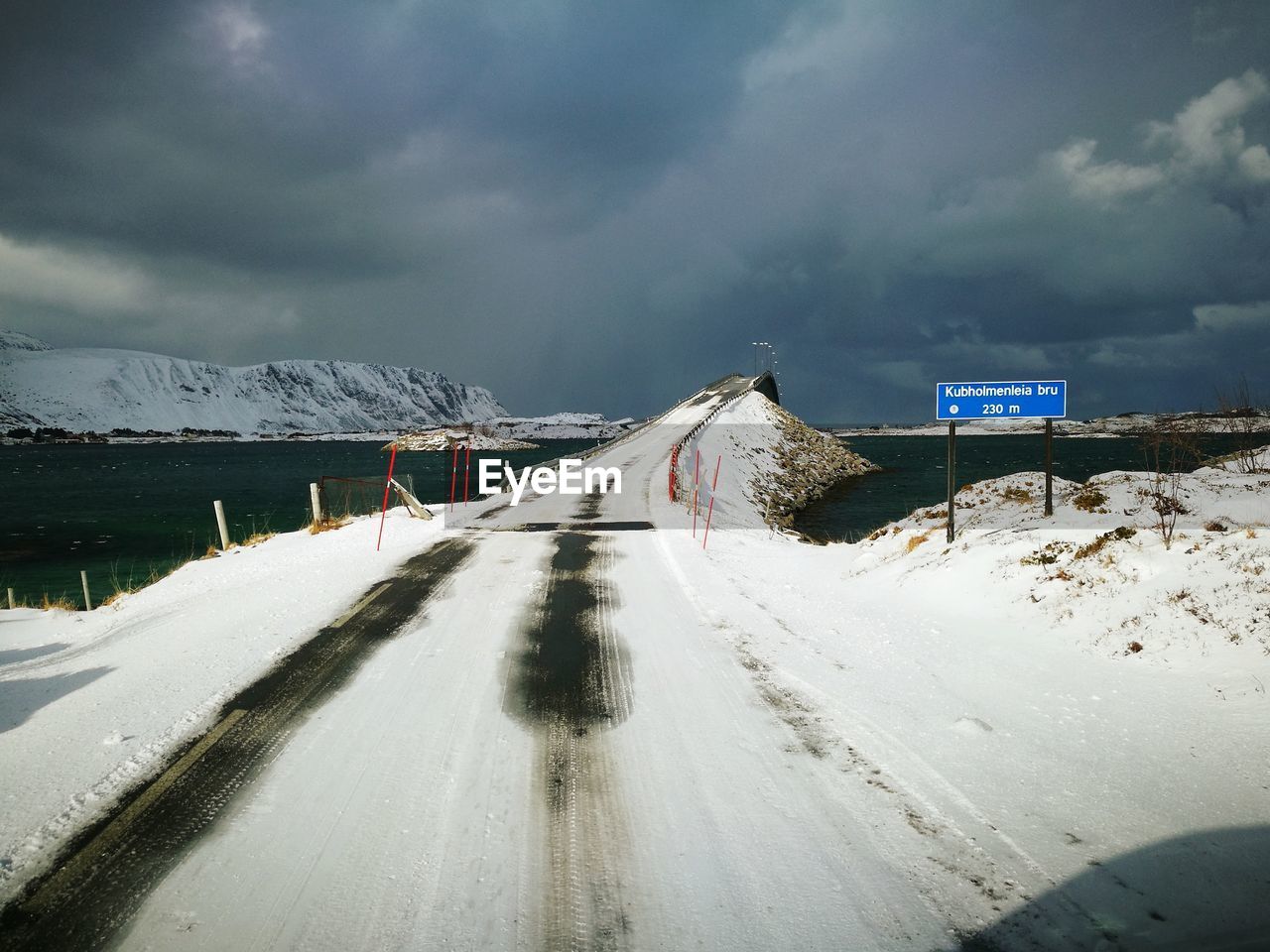 Road leading towards snow covered mountain against sky