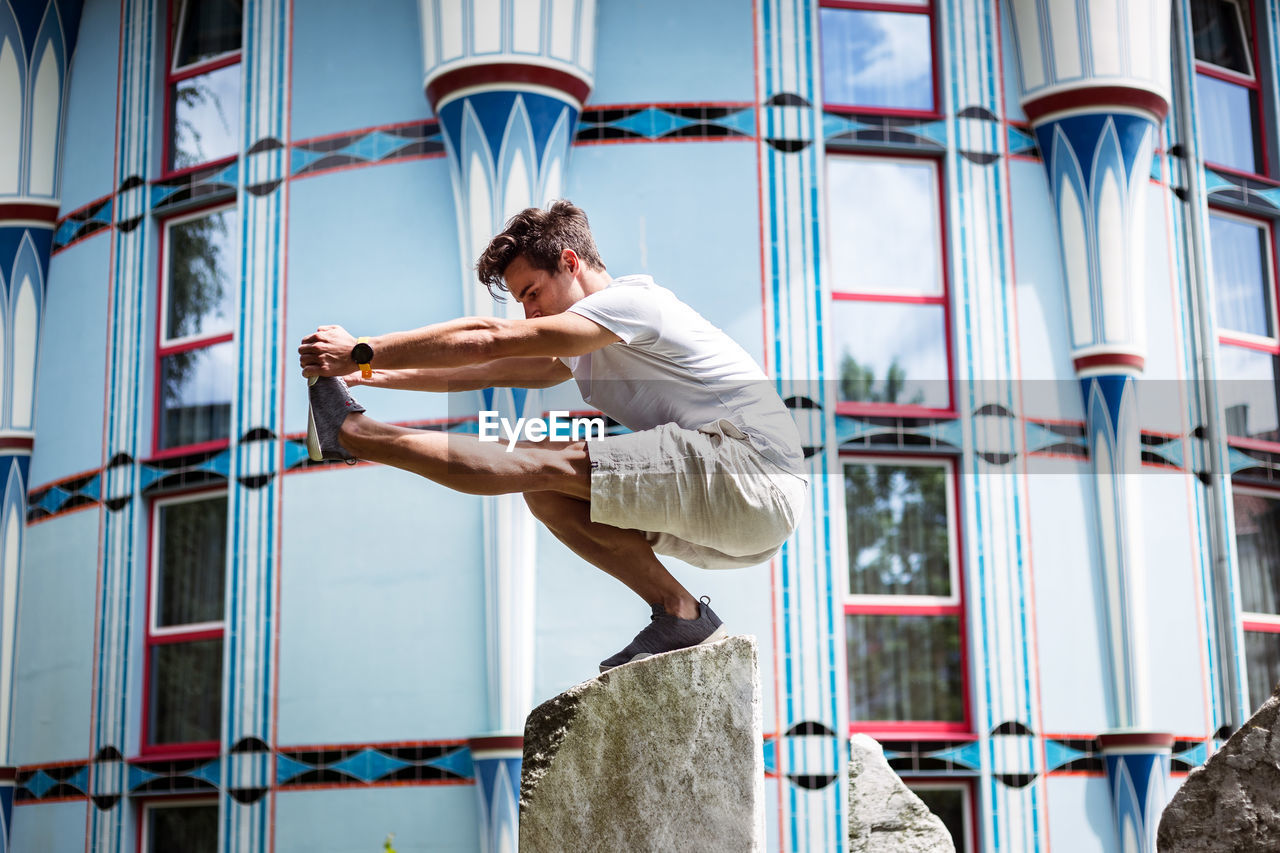 Young man exercising on stone