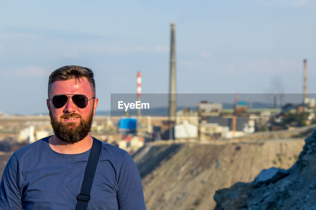 Portrait of young man wearing sunglasses against sky