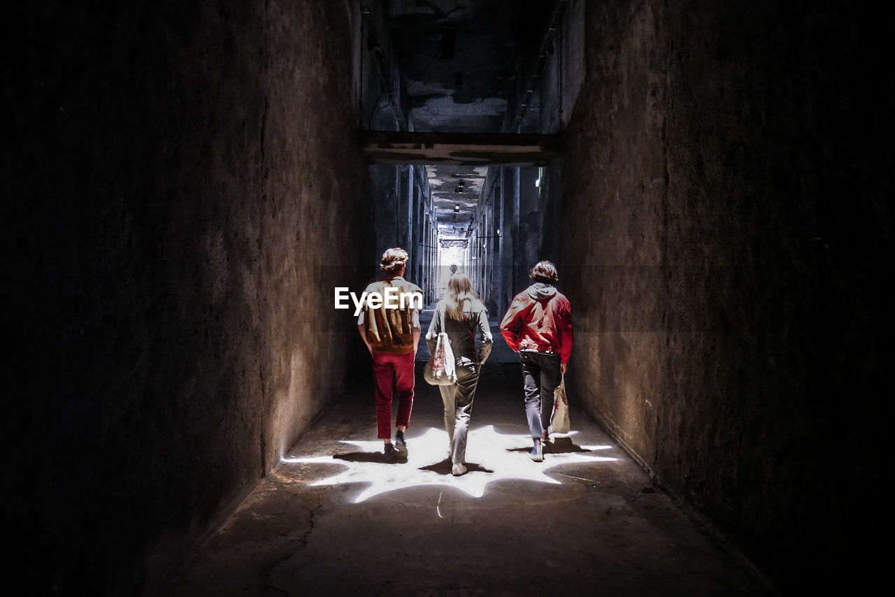 REAR VIEW OF PEOPLE WALKING IN CORRIDOR