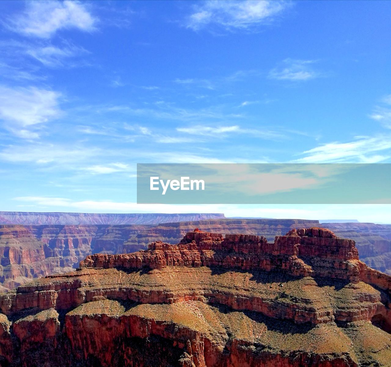 Rock formations on landscape against cloudy sky