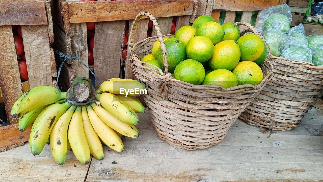 High angle view  banana, lime and guava  in basket  on wooden table