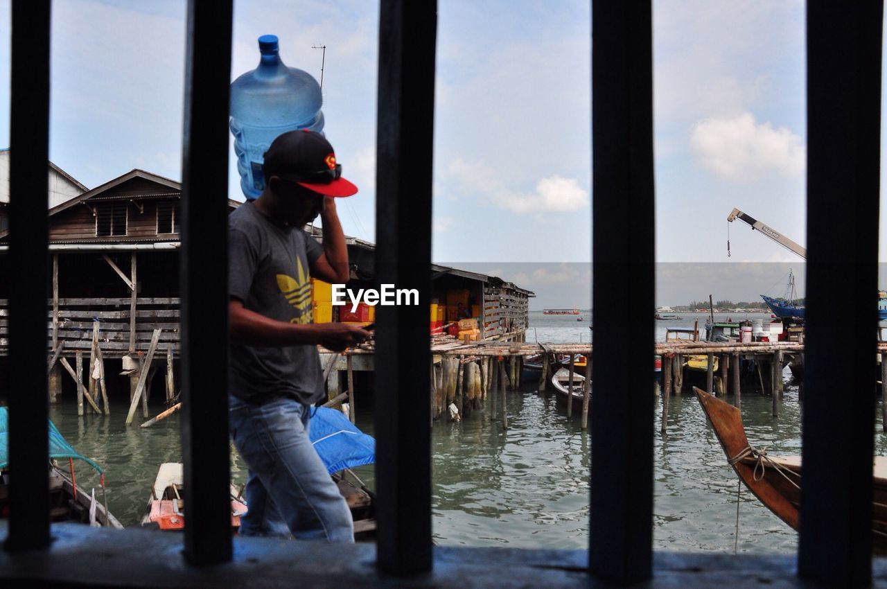 Man seen through window at lake