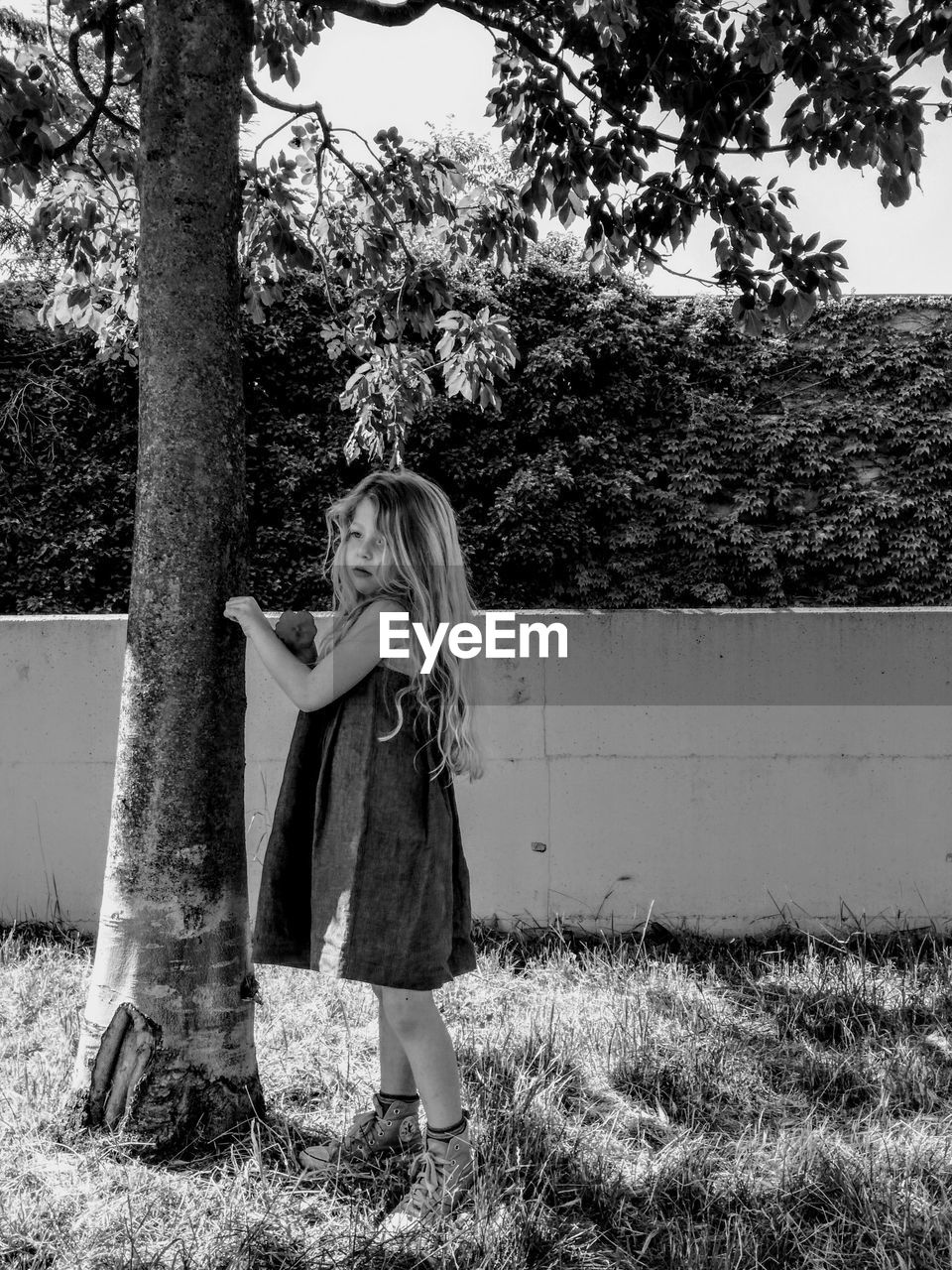 Cute girl standing by tree in park