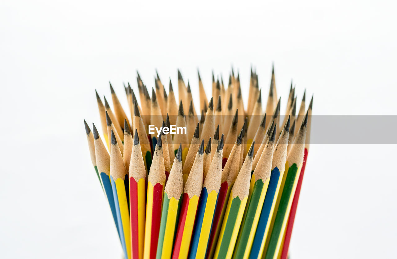 HIGH ANGLE VIEW OF MULTI COLORED PENCILS AGAINST WHITE BACKGROUND