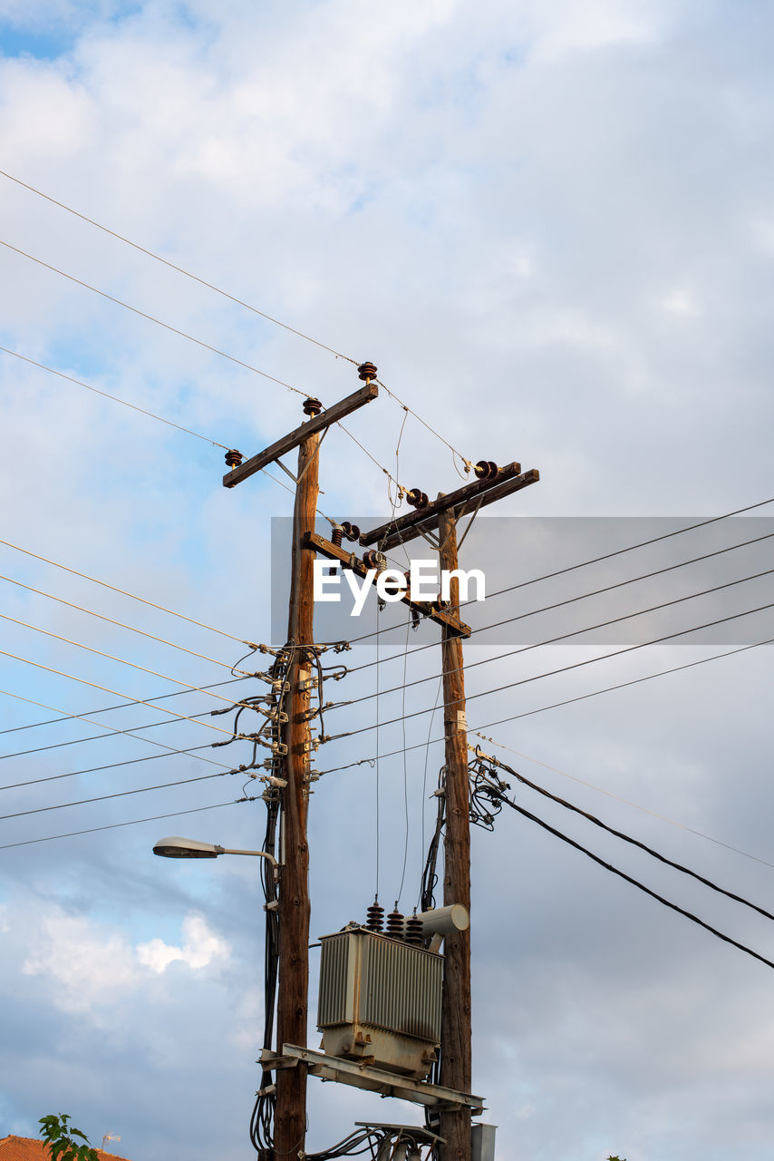 LOW ANGLE VIEW OF CRANES AGAINST SKY AT DUSK