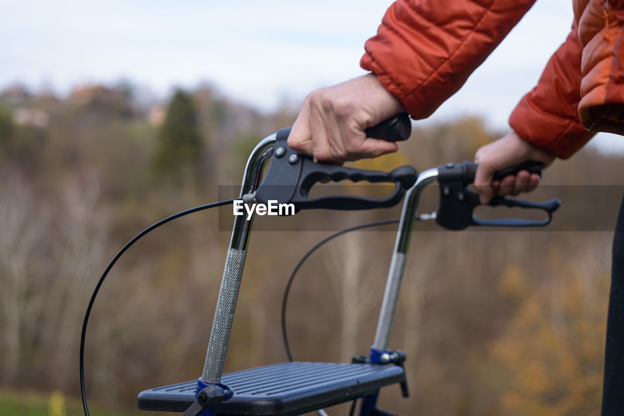 Midsection of disabled person with walker on road