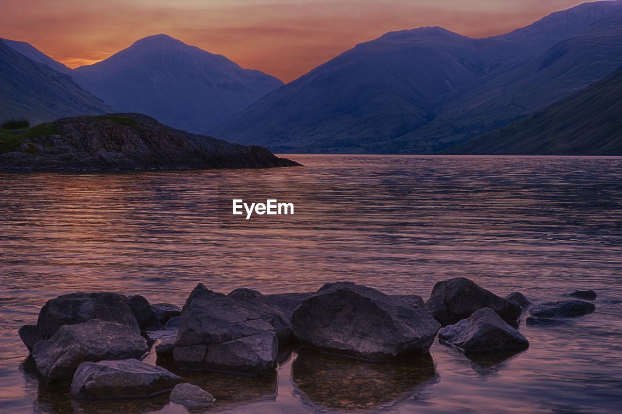 View of calm sea against mountain range