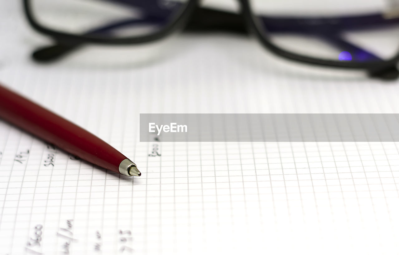 HIGH ANGLE VIEW OF EYEGLASSES ON BOOK