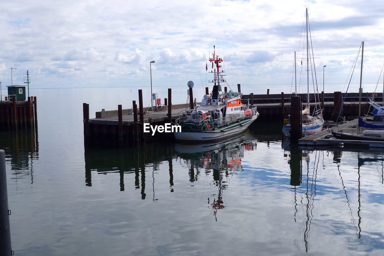 Tugboat moored at lake against sky