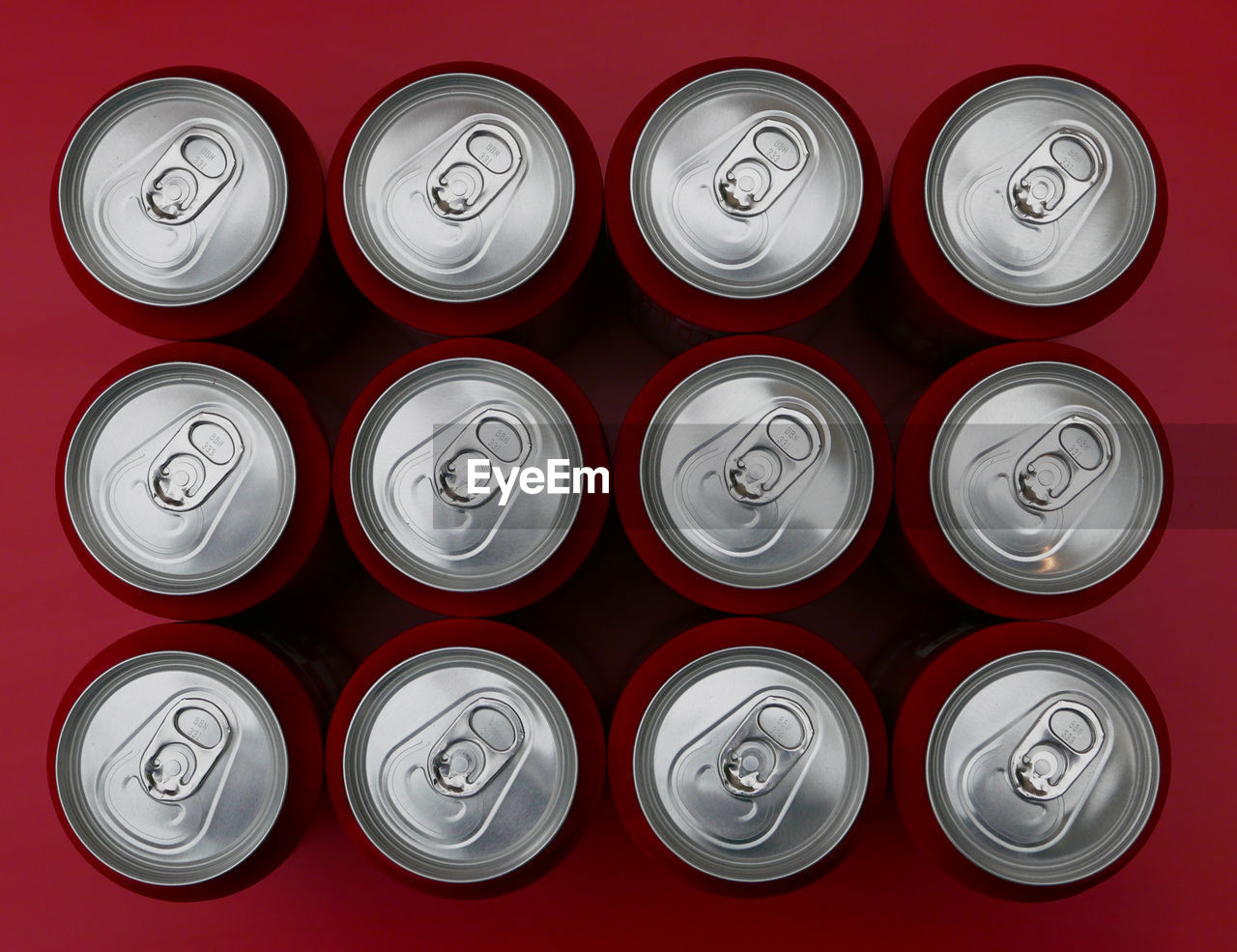 High angle view of drink cans arranged on red table