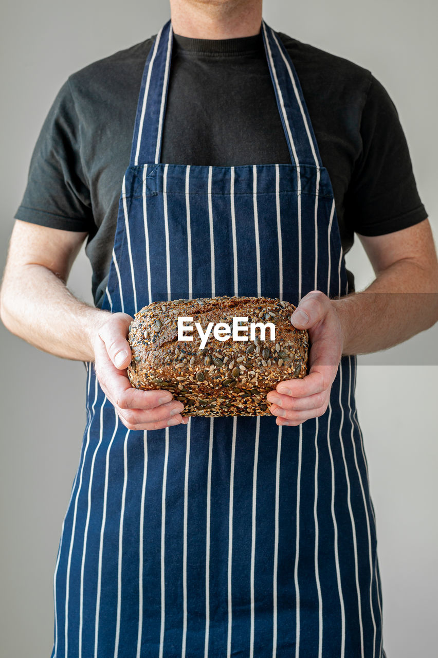 MIDSECTION OF MAN PREPARING FOOD ON TABLE