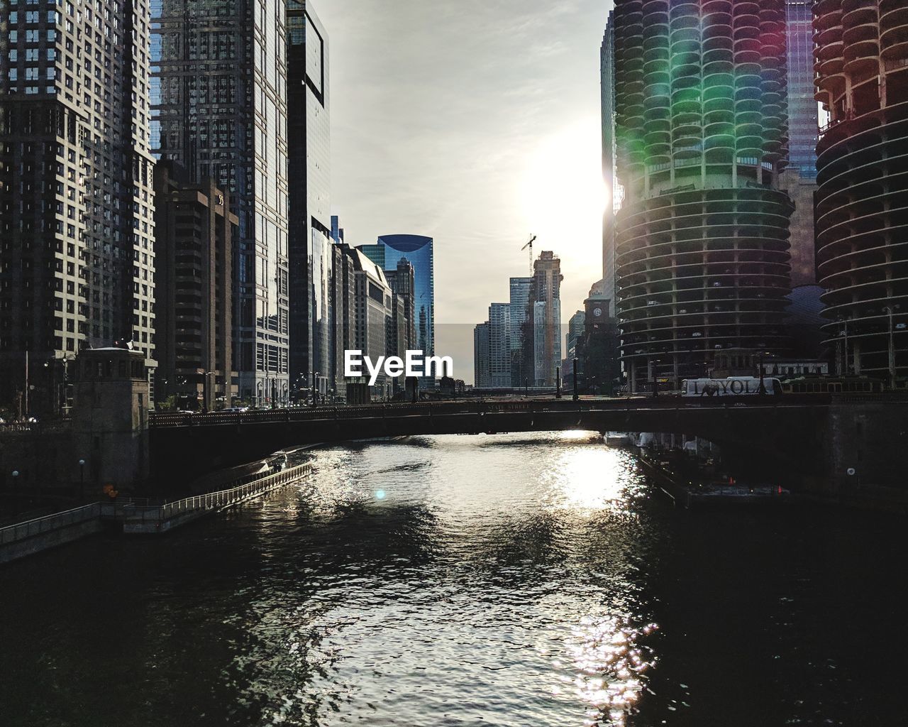 RIVER BY MODERN BUILDINGS IN CITY AGAINST SKY