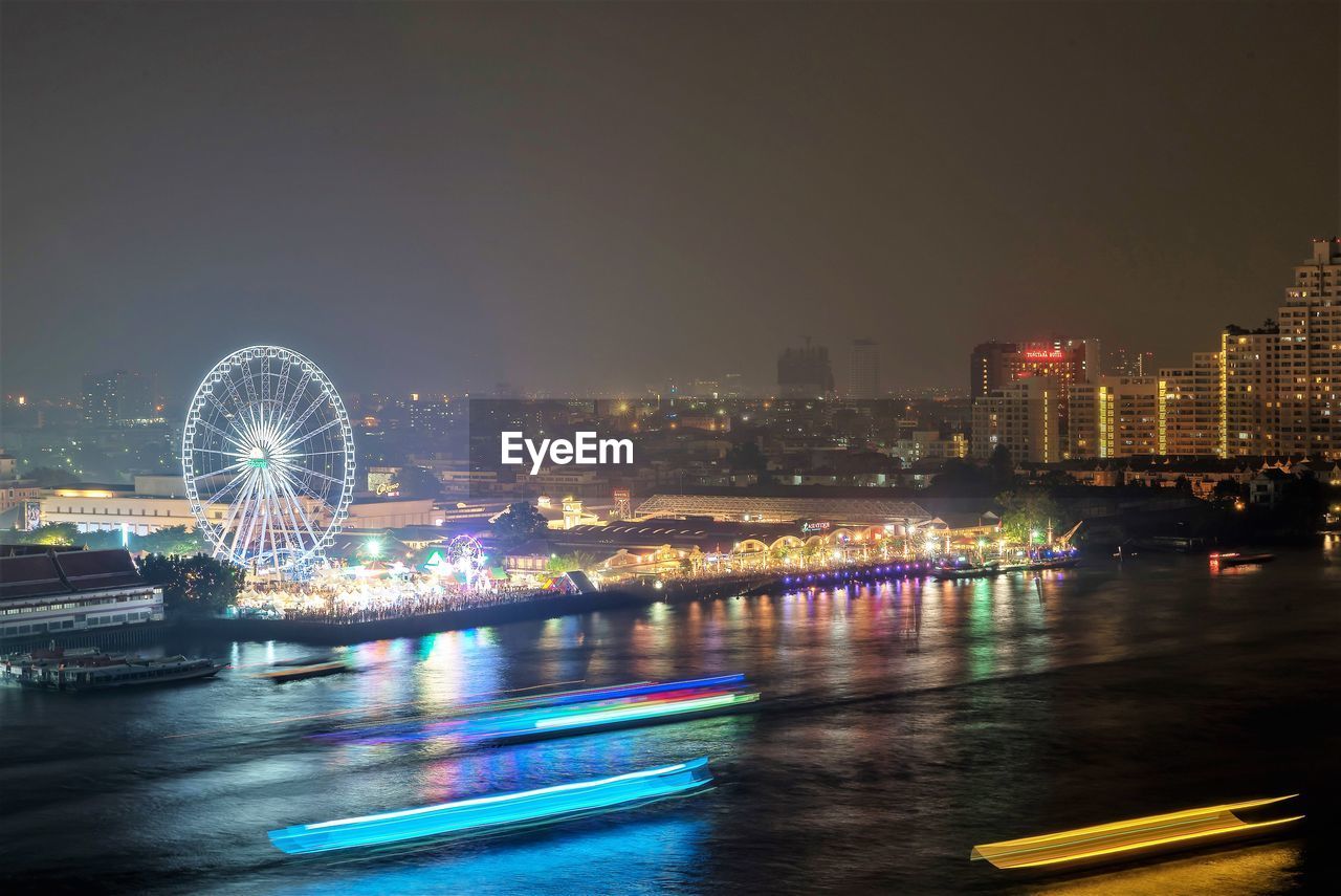 ILLUMINATED FERRIS WHEEL AGAINST SKY AT NIGHT