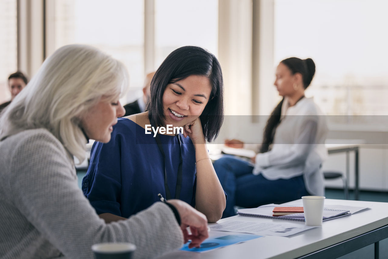 Smiling women sitting together in class