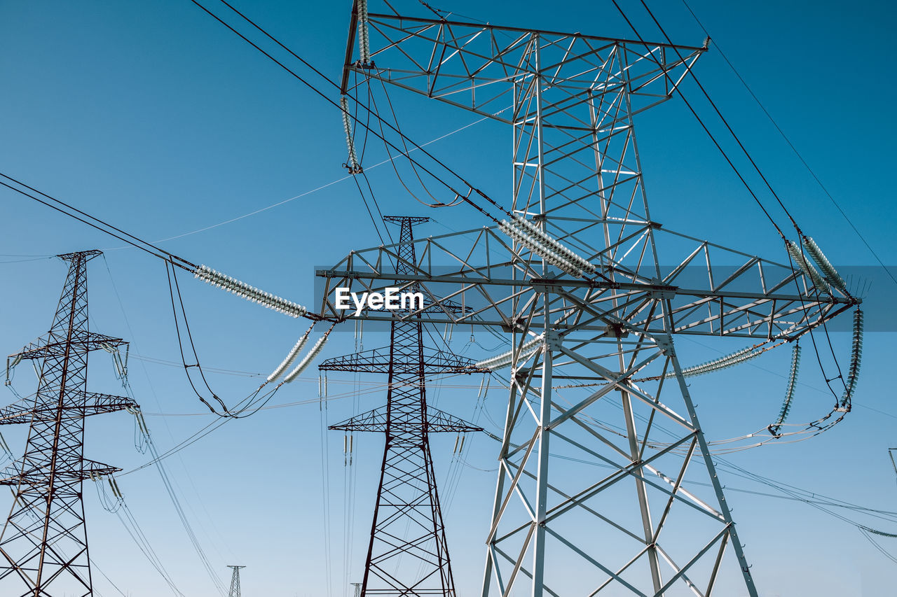 low angle view of electricity pylon against blue sky