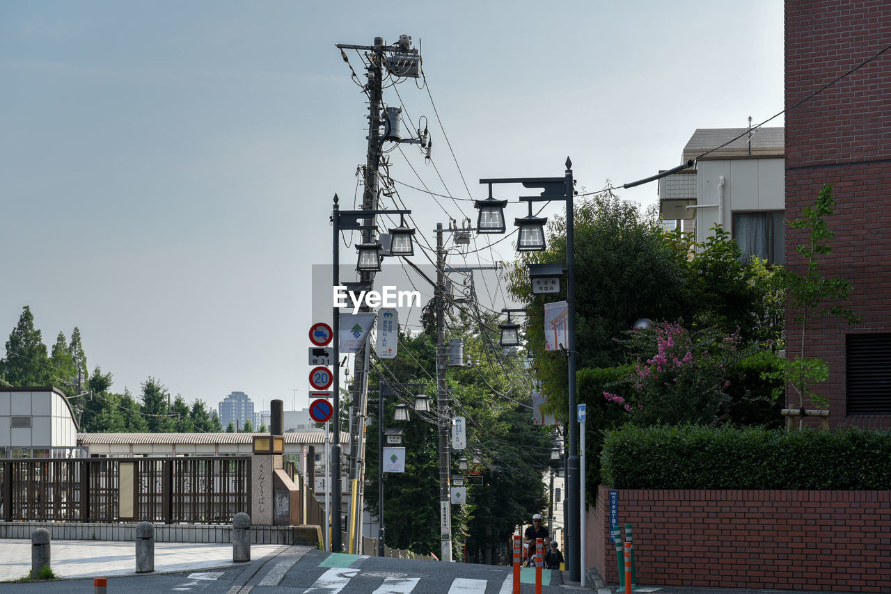 ROAD BY BUILDINGS AGAINST SKY