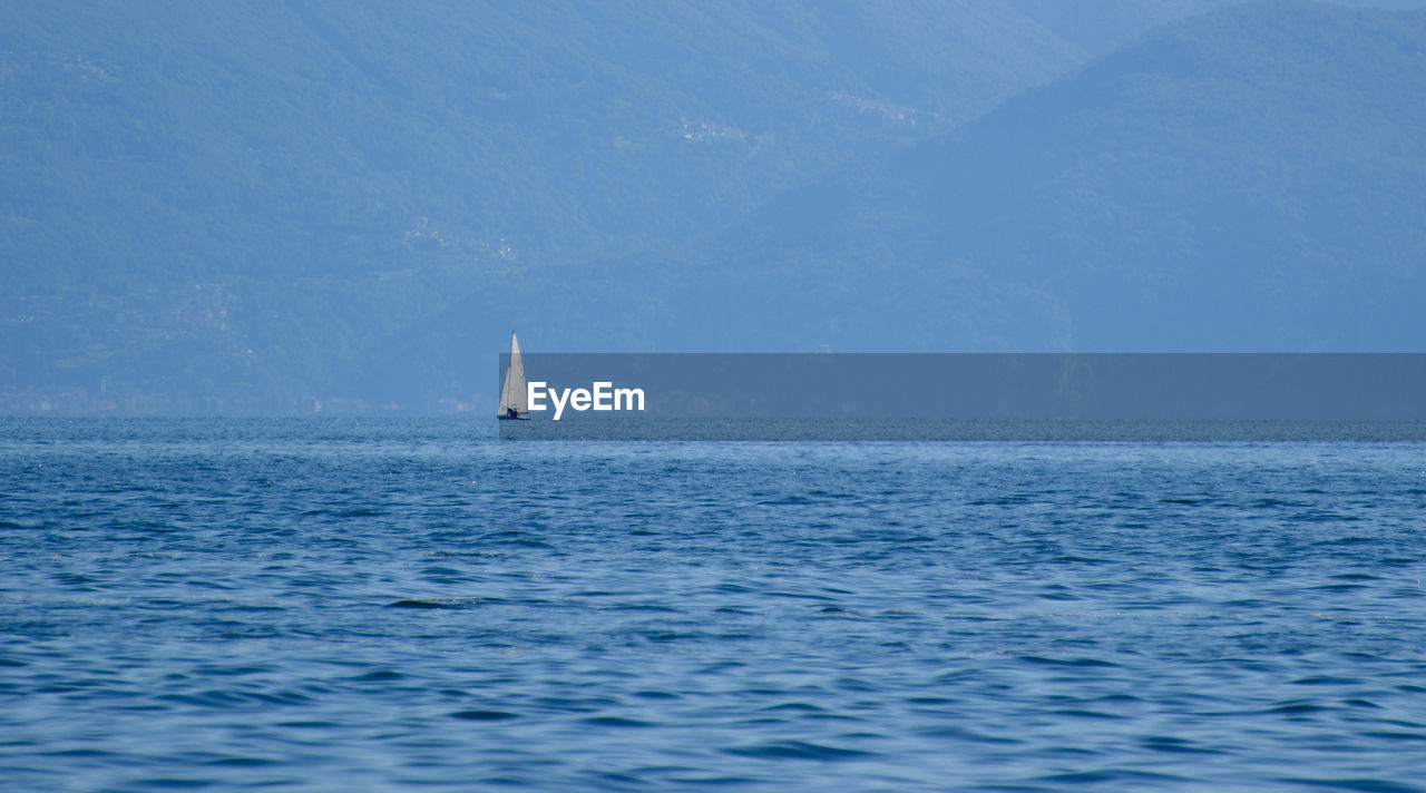 Sailboat in sea against sky