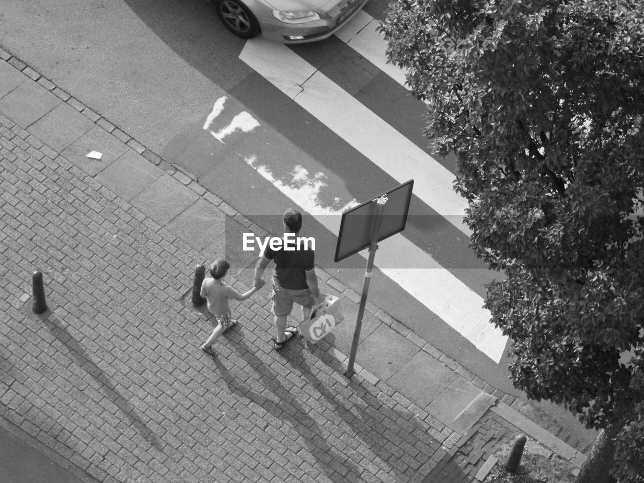 High angle view of man and son walking on street