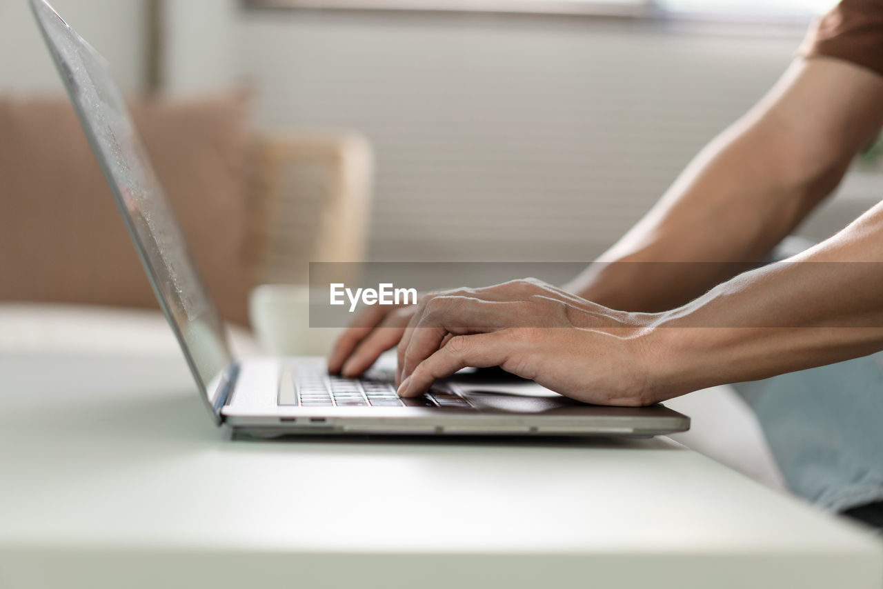 midsection of woman using laptop at table