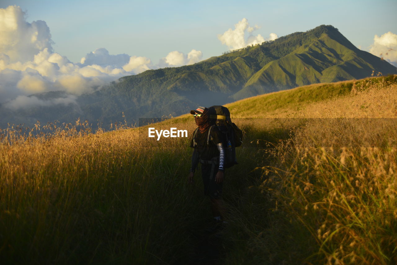 Man standing on hill against mountain