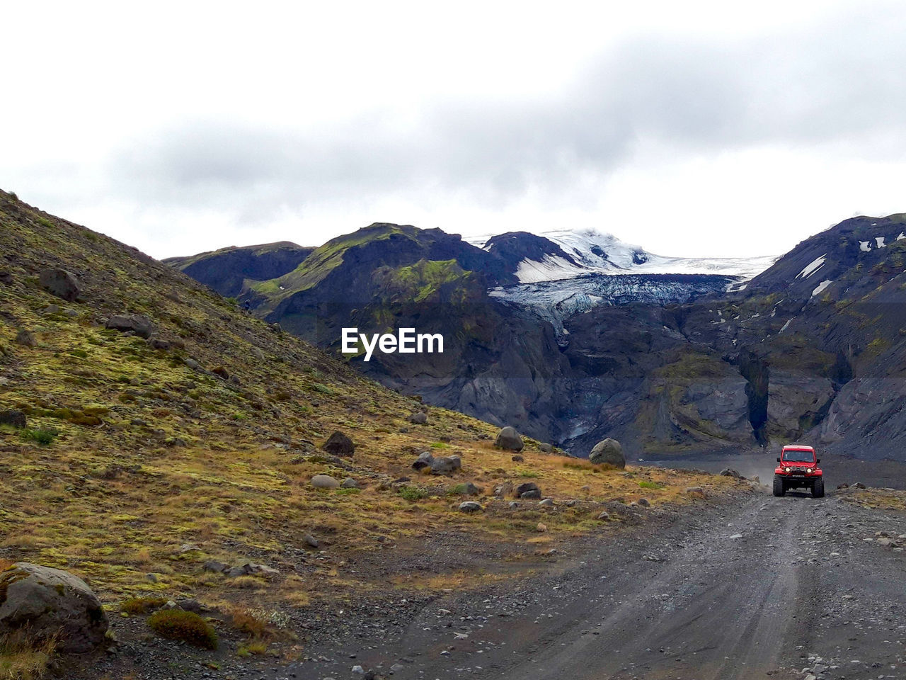 CARS ON ROAD AGAINST MOUNTAINS