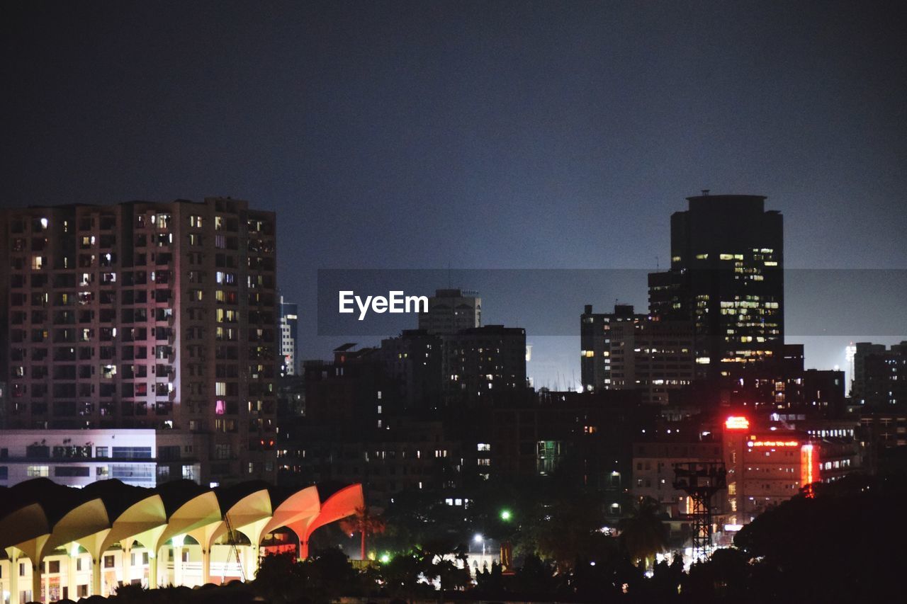 ILLUMINATED BUILDINGS IN CITY AGAINST SKY