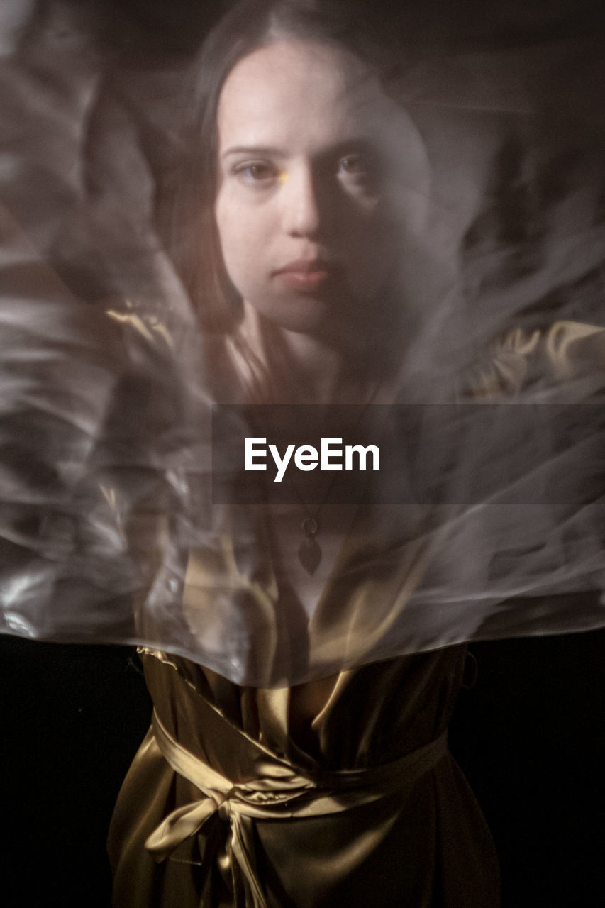 one person, adult, portrait, women, young adult, mystery, studio shot, dark, darkness, smoke, fantasy, indoors, black background, looking at camera, religion, female, spirituality, fashion, contemplation, looking, serious, front view, digital composite, black