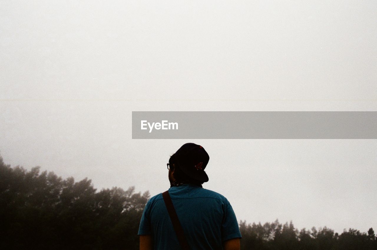 SILHOUETTE OF WOMAN STANDING ON TREE