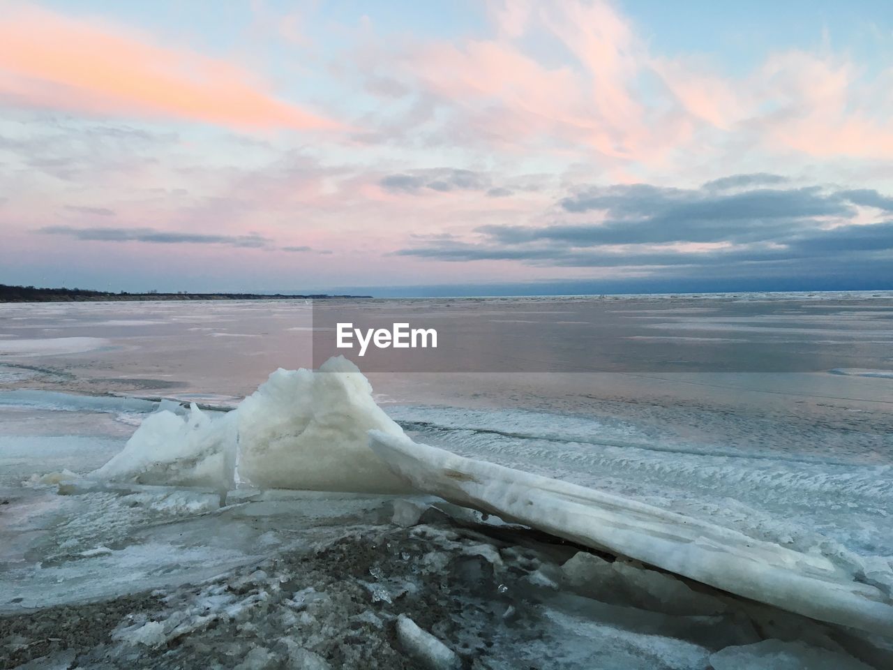 Scenic view of frozen sea against sky during sunset