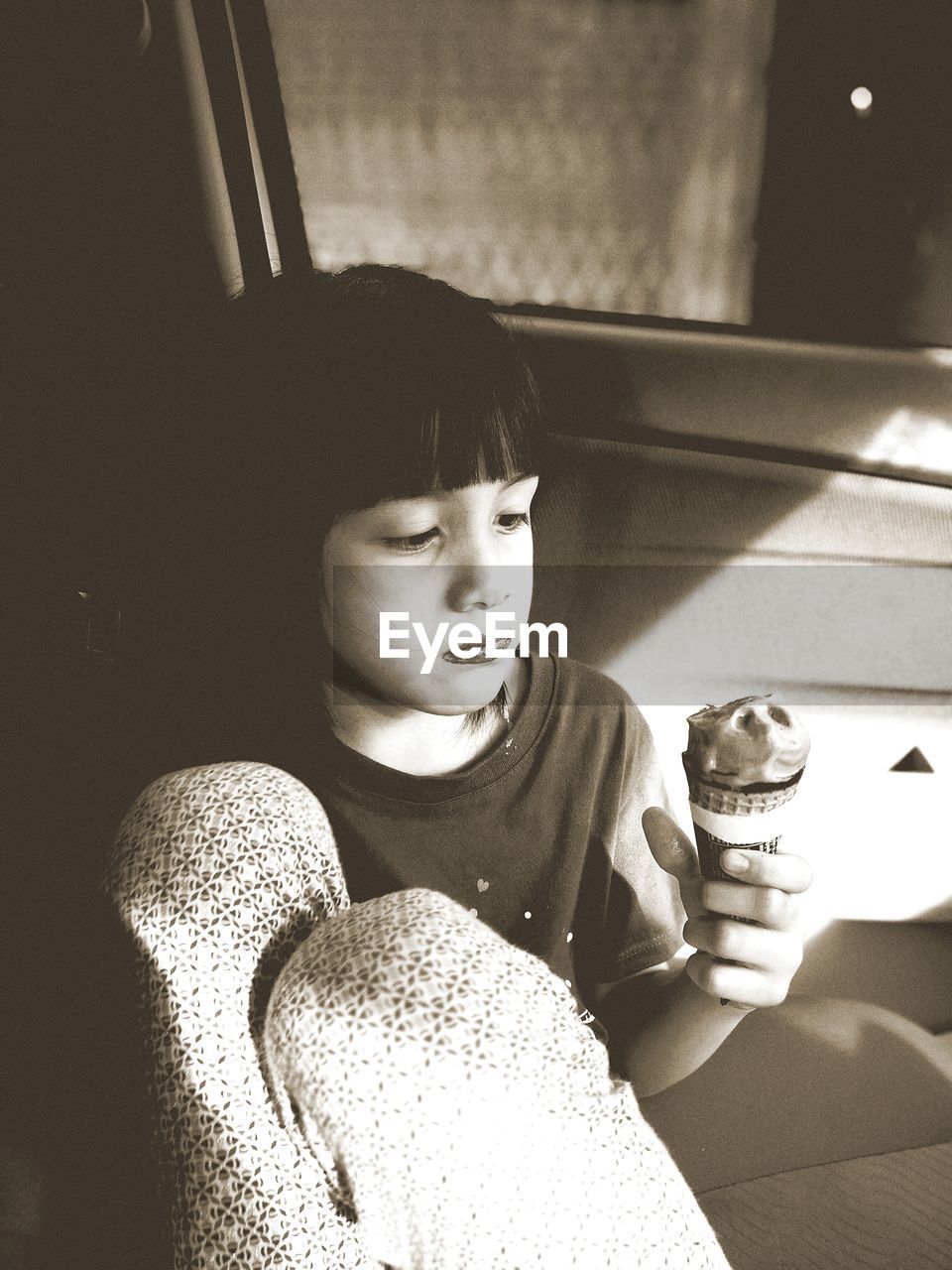 Girl eating ice cream while sitting in car