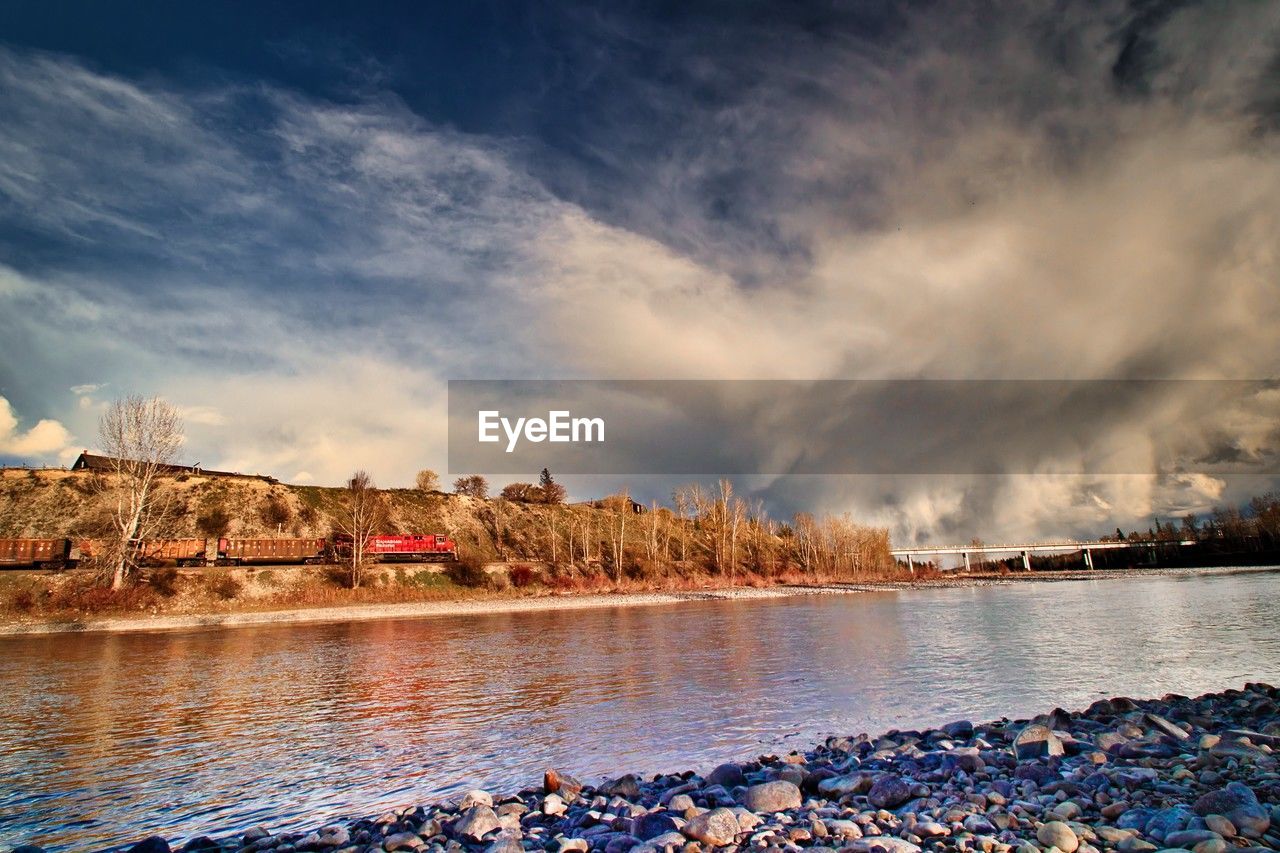 reflection, water, sky, evening, sea, cloud, dusk, nature, sunset, shore, architecture, horizon, sunlight, beauty in nature, environment, travel destinations, land, scenics - nature, built structure, building exterior, landscape, no people, body of water, wave, coast, rock, outdoors, travel, city, nautical vessel, building, beach, cityscape, tranquility, tree