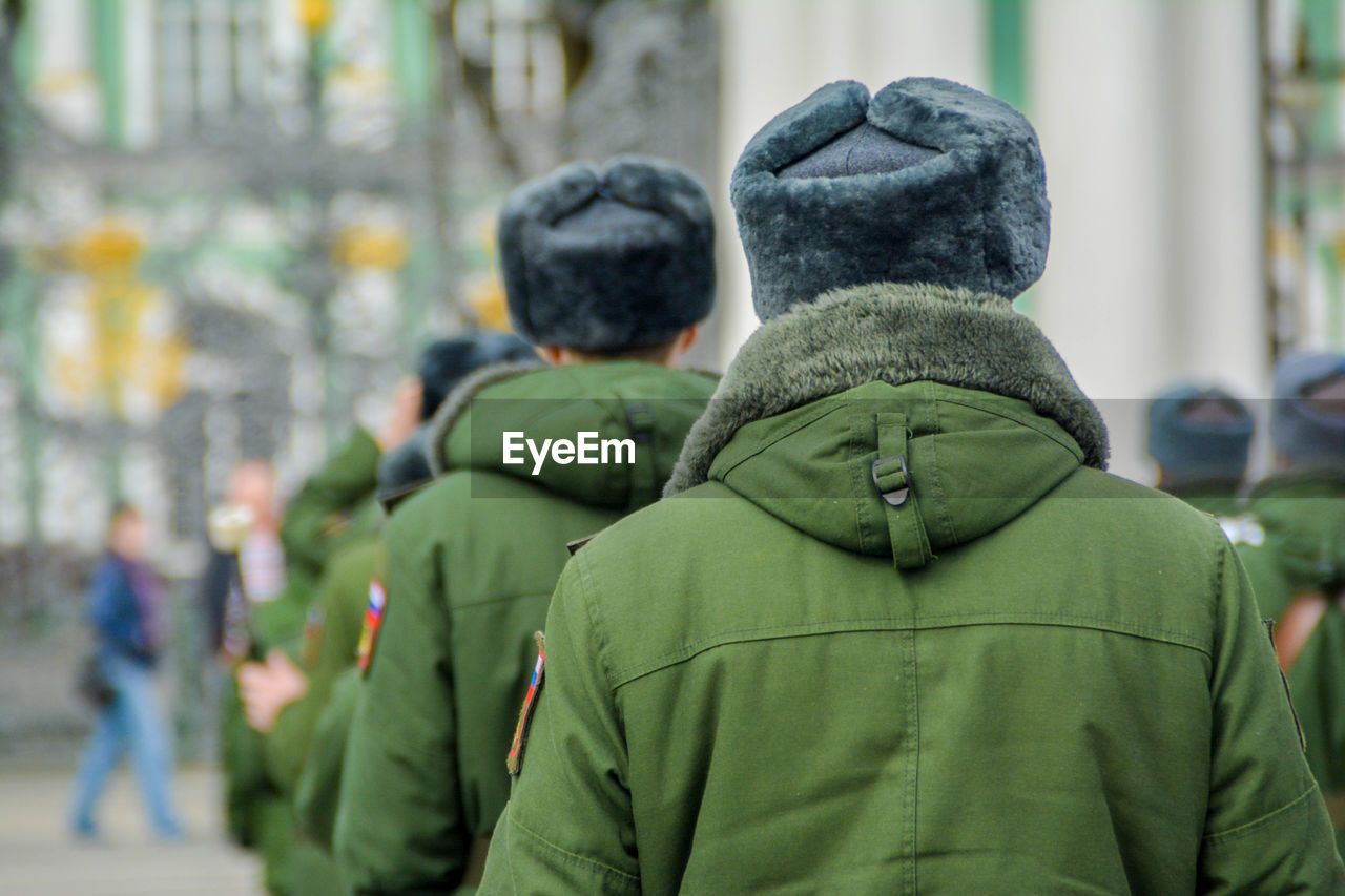 Rear view of men in warm clothing walking on street