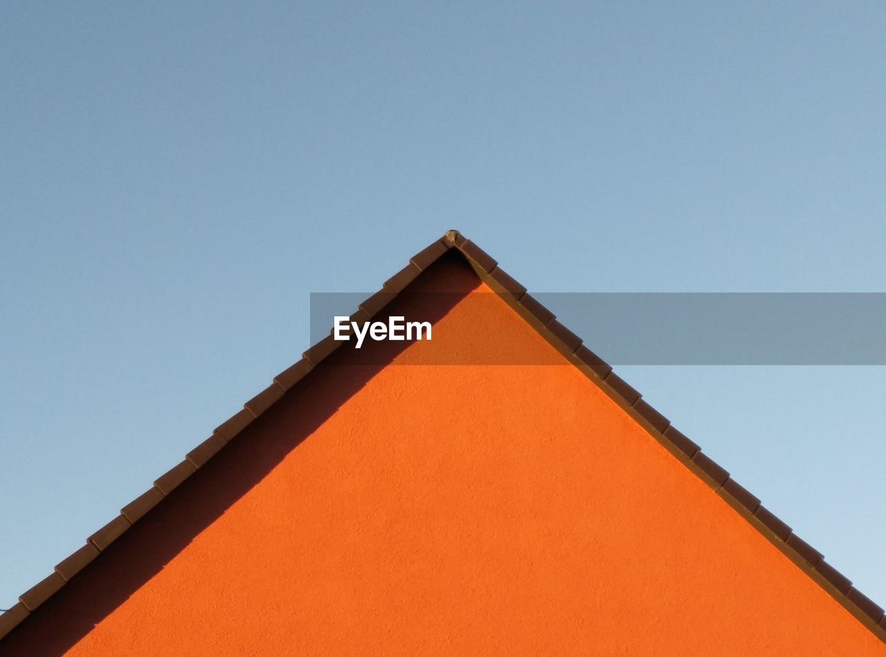 Low angle view of orange building against clear sky