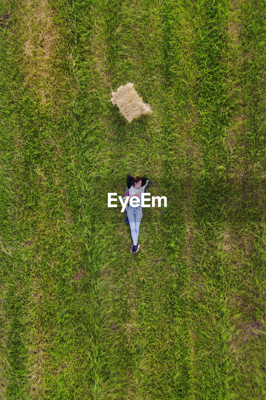 Aerial view of woman lying on field