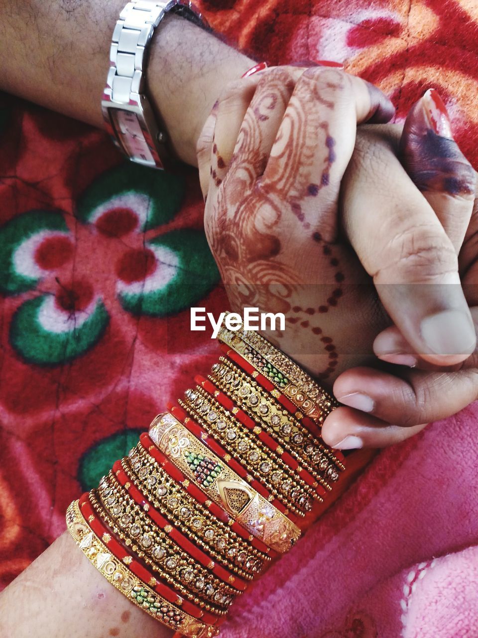 Cropped image of bride and bridegroom holding hands