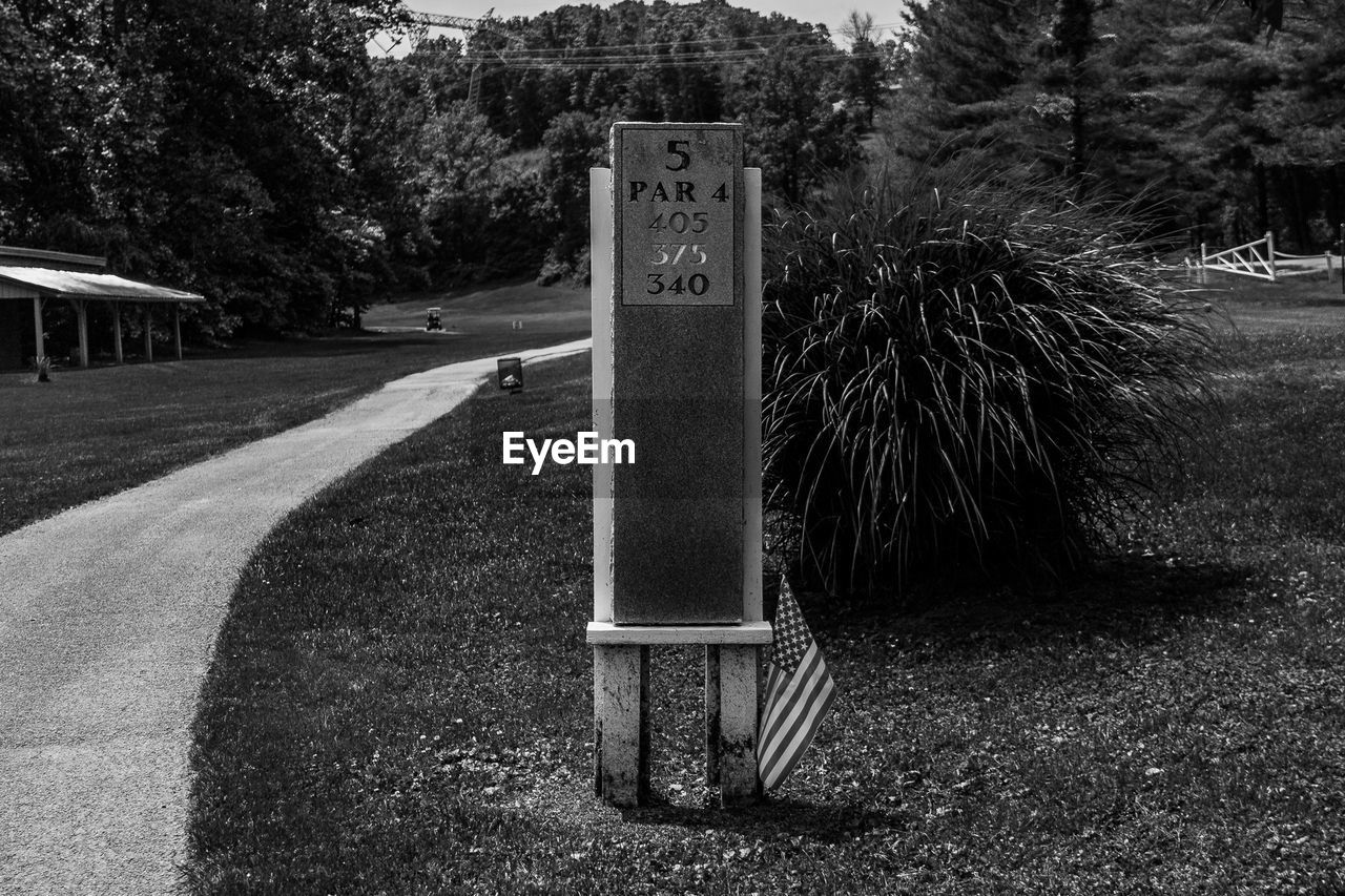 CLOSE-UP OF ROAD SIGN AGAINST TREE