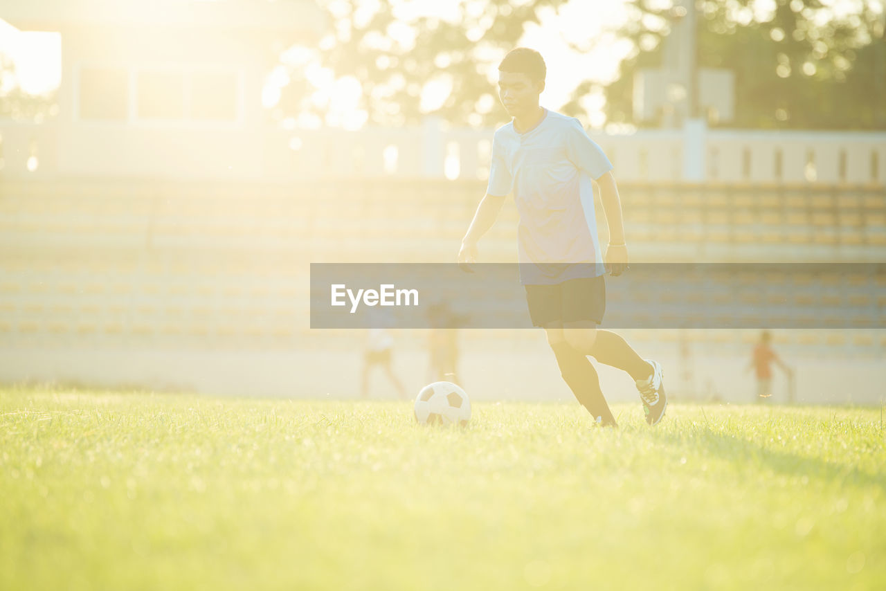 PEOPLE PLAYING SOCCER BALL ON GRASS