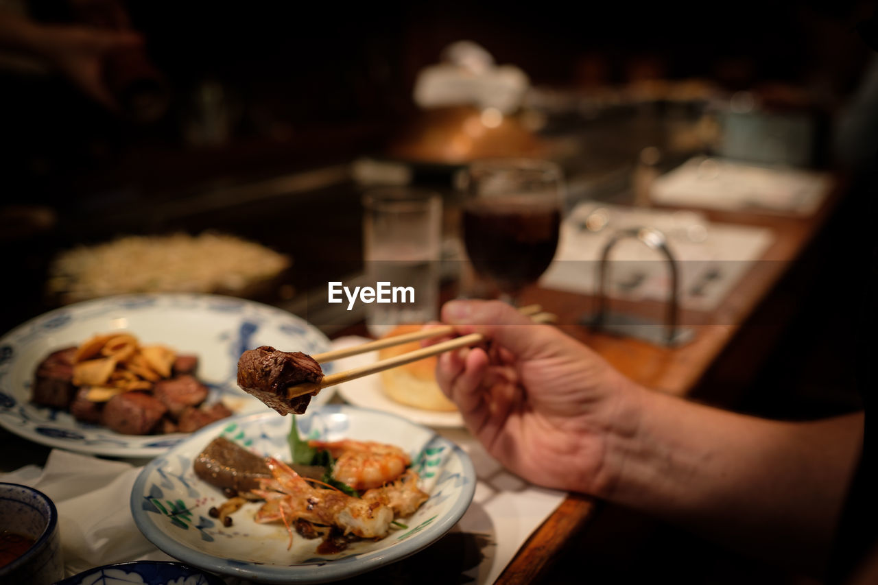 Cropped image of hand having food at restaurant
