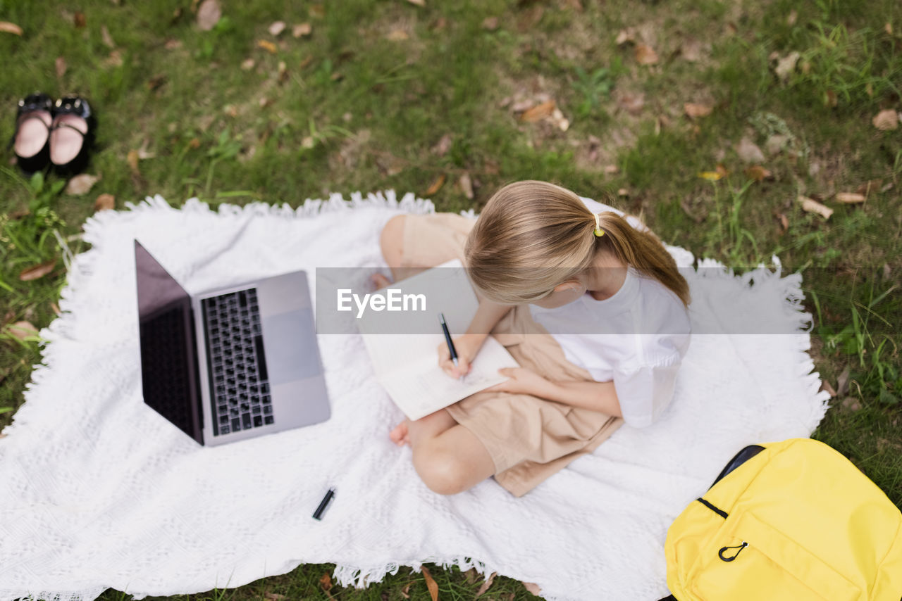 High angle view of woman sitting on field